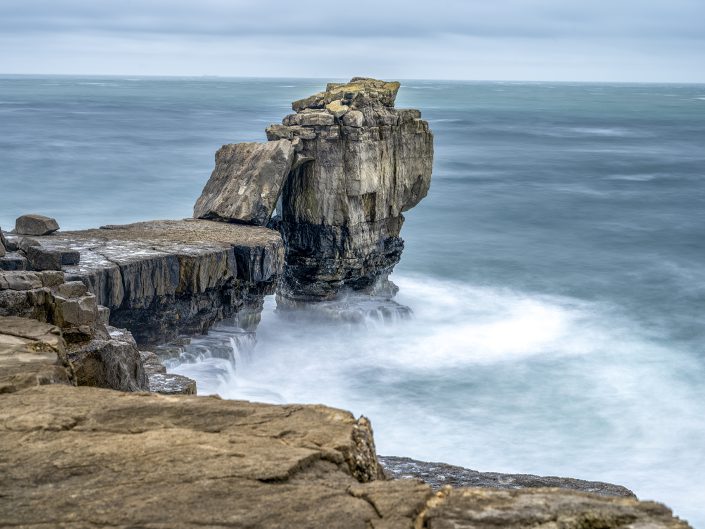 long exposure waterscape photo of the impressive Pulpit Rock at high tide in Cornwall