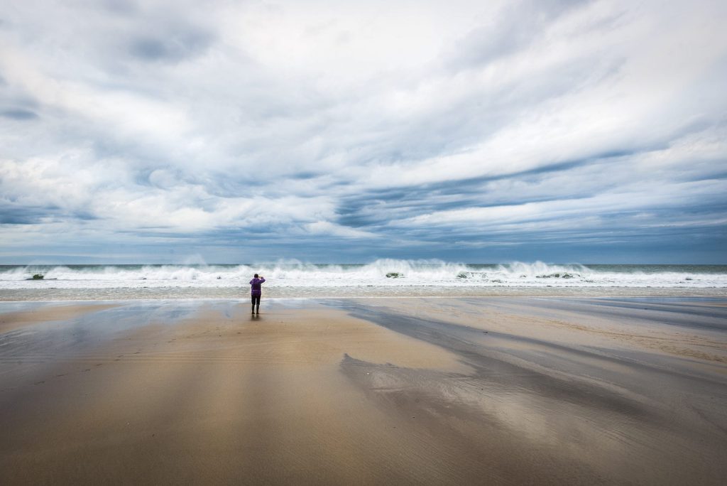 seascape photo of a person taking photos of the waves