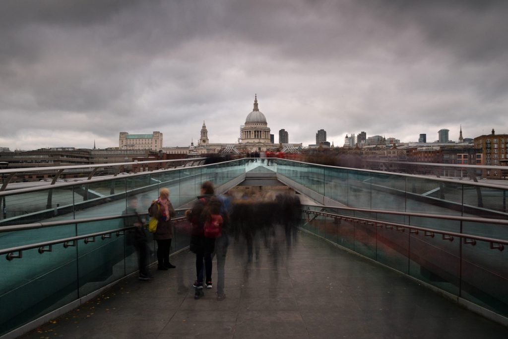 A cityscape photo on the Millenium Bridge in London with more prolonged exposure blurs people out.