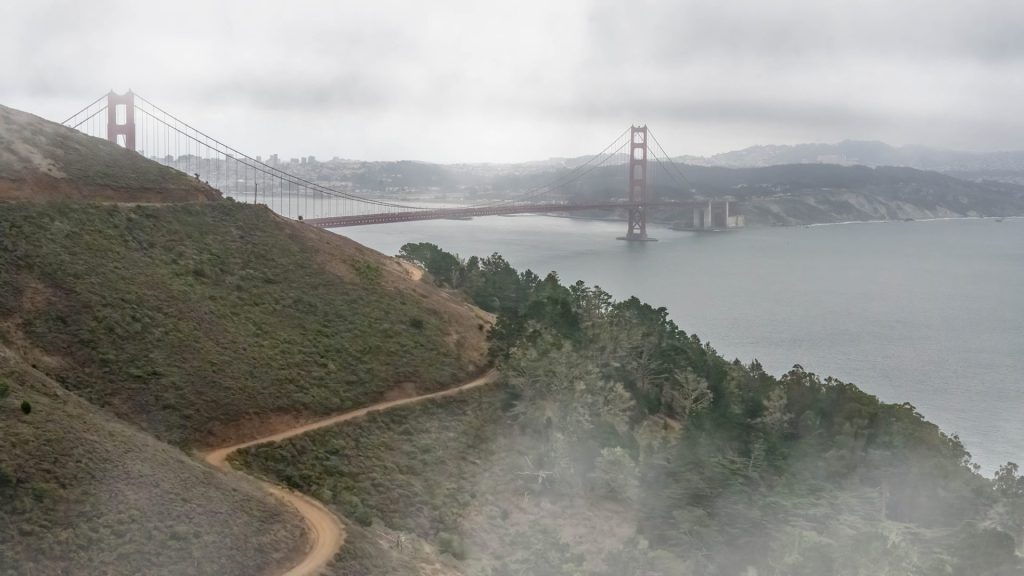 Landscape photo of the Golden Gate Bridge in the mist with a dirt road as the leading line.