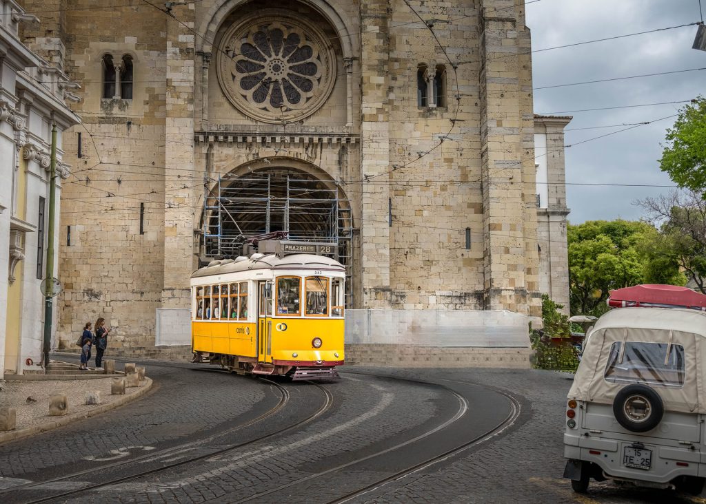 Cityscape photo of a typical Lisbon tram in front of the Cathedral